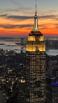 the empire building is lit up at night in new york city, ny with its lights on