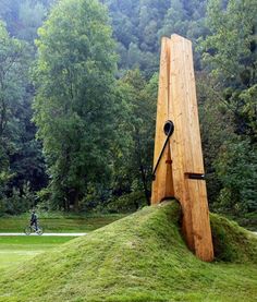 a large wooden object sitting on top of a lush green field