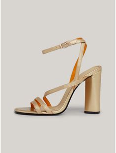 Tommy Hilfiger women's shoe. Revive your night-out shoe collection with these strappy sandals that sit on a chunky block heel and showcase luxe branded hardware.  Material: 100% Leather (fwa). Gold Block Heel With Buckle Closure, Chic Gold Block Heels With Heel Strap, Gold Block Heel Heels With Buckle Closure, Gold Block Heels With Buckle Closure For Spring, Gold Block Heel Shoes With Buckle Closure, Glamorous Leather Block Heels, Chic Gold Block Heels With Stacked Heel, Gold Open Heel Block Heels For Night Out, Modern Gold Block Heel Shoes