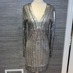 Beautiful Silver Beaded V-Neck, Long Sleeve Mini Dress! Size Medium (Fits 4-6) Has A Little Stretch So It's Very Comfortable And Forgiving. Worn Once And Is In Great Condition- A Few Beads May Be Missing Here And There But Nothing Noticeable Chic Sequined V-neck Dress For Party Season, Embellished V-neck Dress For Date Night, Embellished Fitted V-neck Mini Dress, Embellished V-neck Evening Mini Dress, Holiday V-neck Embellished Sequin Dress, Spring V-neck Embellished Sequin Dress, Sequin Mini Length V-neck Evening Dress, V-neck Sequin Dress For Spring Evenings, V-neck Embellished Dress For Date Night