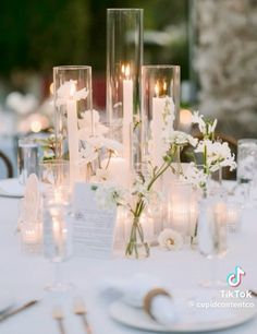 the table is set with candles, flowers and place settings for an elegant dinner party