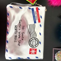 a white bag sitting on top of a table next to a pink feathered object