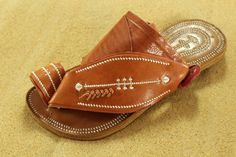 Use code COMBINEDSHIPPING and get $50 off your second pair. You will love these traditional Arabian sandals. The straps and soles are made of leather. The leather lining will feel so soft and comfortable against your foot. They are designed to fit your foot loosely with lots of room in the toe-ring and straps. The leather sole will mold and shape to your foot over time, even creating an arch against the bottom of your foot after you break them in. The supple leather is camel-color with white det Summer Closed Toe Slippers With Stitched Sole, Traditional Huarache Sandals With Woven Sole For Vacation, Traditional Huarache Sandals With Woven Sole For Beach, Adjustable Sandals With Rubber Sole For Festival, Leather Toe Ring Sandals With Rubber Sole For Beach, Leather Sole Slip-on Toe Ring Sandals For Beach, Brown Leather Sole Toe Ring Sandals For Beach, Beach Slip-on Toe Ring Sandals With Leather Sole, Beach Slip-on Toe Ring Sandals With Rubber Sole