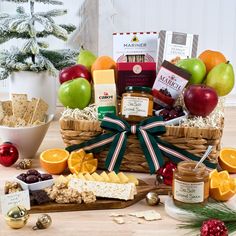 an assortment of fruit, crackers and cheeses in a wicker basket on a table