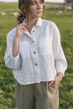 "An Oversized Linen Shirt is for sure a wardrobe staple for all times. Classic modest style is moderately embellished with stylish patch pockets. This white button up shirt can be favorably combined both with loose and classic bottoms. A slightly cropped design delicately hints at the waistline. Thus, it creates a perfect balance to a current-day trend on oversized clothes. DETAILS ⚬ Spread collar. ⚬ Patch pockets are decorated with handmade fancy stitches. ⚬ Button fastening. ⚬ 3/4 sleeve. ⚬ Sl White Long Sleeve Shirt With Pockets, White Collared Blouse With Pockets, White Tops With Roll-up Sleeves For Everyday, White Shirt With Pockets And Casual Collar, White Button-up Tops With Buttons, Casual Top With Buttons And Lapel Collar, Casual White Shirt With Lapel Collar, White Shirt With Pockets And Lapel Collar, Casual White Top With Lapel Collar