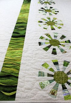 a quilted table runner with green and white designs