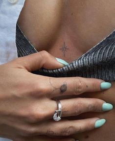 a woman's stomach with tattoos on her left side and an arrow tattoo on her right hand