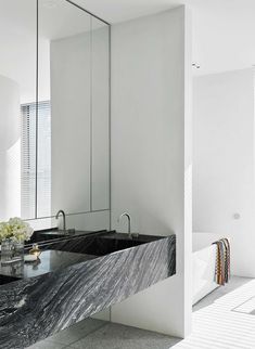 a bathroom with marble counter tops and white walls