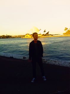 a man standing in front of the sydney opera house