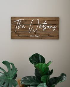 a wooden sign that says the waters on it next to some plants and a potted plant