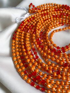 "Oupoyo" – a Single Strand Waist Bead that brings together the rich warmth of orange crystal glass seed beads and the subtle opulence of gold glass seed bead accents. ✨ Vibrant Orange Radiance: Oupoyo exudes a radiant glow with its vibrant orange crystal glass seed beads, reflecting the energy of the sun and infusing your ensemble with a lively and spirited charm. 🌟 Gold Opulence: Interspersed among the beads are golden accents, evoking a sense of opulence and sophistication. The gold glass seed beads enhance the waist bead's overall allure, adding a touch of luxury to your style. 🎀 Simple and Elegant Design: Oupoyo features a single-strand design, gracefully encircling the waist with simplicity and elegance. The streamlined silhouette ensures versatility, allowing you to effortlessly en Strong Hand, Orange Crystals, Glass Seed Beads, Gold Glass, Vibrant Orange, Green Crystals, Deep Green, How To Make Beads, Seed Bead