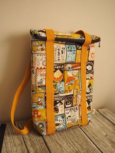 a yellow and blue bag sitting on top of a wooden table next to a wall