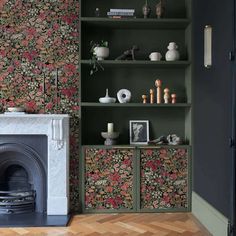 a living room filled with furniture and a fire place in front of a wallpapered fireplace