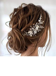 a woman wearing a bridal hair comb with flowers on it's headband