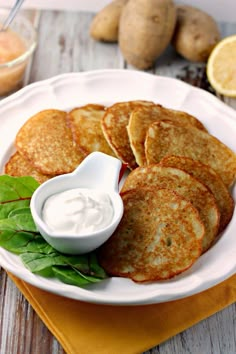 some pancakes on a white plate with ranch dressing