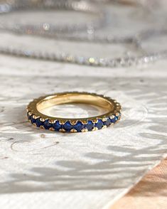 The Audrey Ring has all the royal blue vibes. Perfect for stacking with other rings in your collection or for a simple chic look. This ring is 18k gold plated silver with cubic zirconia stones. This is for one ring. Ring sizes: 6,7,8 Blue Gold Ring, Timeless Blue Cubic Zirconia Rings, Classic Gold Eternity Band With Gemstone, Blue Gold-plated Rings For Gifts, Gold Plated Blue Rings As Gift, Blue Gold Plated Rings As Gift, Yellow Gold Sapphire Stackable Rings With Round Cut, Blue Gold Plated Rings For Gift, Elegant Blue Eternity Band With Vvs Clarity