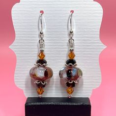 These colorful earrings are made with orange and brown lampwork beads, brown Swarovski crystals, sterling silver bead caps and small round sterling silver beads. They measure approximately 1 3/4 inches from the top of the sterling silver earwire. Click here to see other earrings in my shop: https://www.etsy.com/shop/JewelryDesignsByRita?section_id=14765680 I have been designing and making jewelry since 2010. I use only the highest quality materials such as Swarovski crystals, Swarovski pearls, g Crystals Swarovski, Lampwork Jewelry, Lampwork Earring, Swarovski Crystal Earrings, Colorful Earrings, Silver Bead, Swarovski Pearls, Bead Caps, Orange Brown