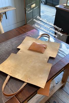 a leather bag sitting on top of a wooden table