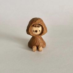 a small wooden figurine with a hood on it's head and eyes