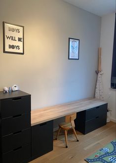 a room with a desk, chair and pictures on the wall above it that says boys will be boys