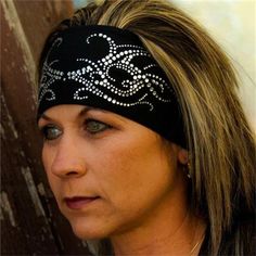 a woman wearing a black headband with white designs on it's side and her eyes closed