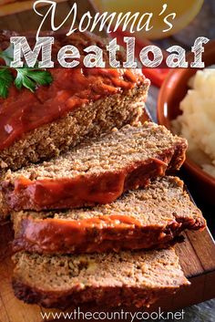 sliced meatloaf on a cutting board with mashed potatoes