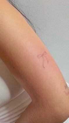 a woman's arm with a small tattoo on the left side of her arm