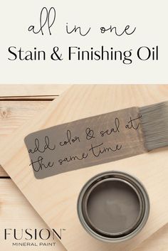 a paint can and brush sitting on top of a wooden table next to a sign that says, all in one stain & finishing oil