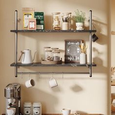 two metal shelves with coffee cups and other items on them in a small kitchen area