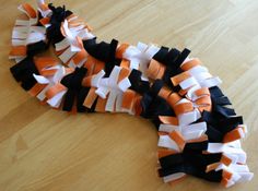 an orange and white ribbon laying on top of a wooden table