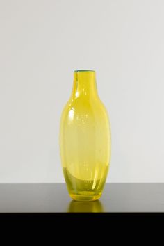 a yellow vase sitting on top of a table