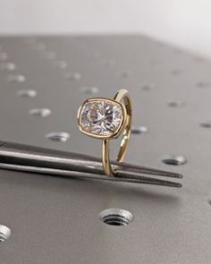 a diamond ring sitting on top of a piece of metal