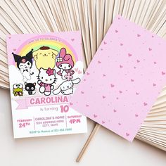 a pink card with three cartoon cats on it next to matchesticks and a fan