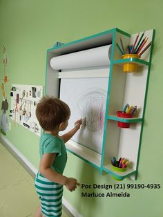 a little boy that is standing in front of a whiteboard