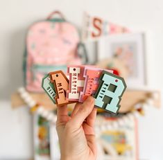 a person holding up small magnets that spell out i love you in different languages