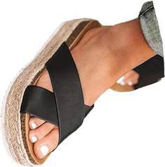 a woman's foot wearing black sandals and an espadding wedged sandal