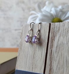 Genuine Faceted Amethyst Ovals are framed in a bright sterling silver basket with sterling hooks for pierced ears. These earrings are lightweight, bright, and a beautiful light purple that evoke the delicate color of Sea Purslane. - Genuine faceted amethyst ovals are 3/8" high and 1/4" wide. - Weight is approximately 1.4 grams.- Crafted of sterling silver Handmade Oval Purple Earrings, Lavender Drop Earrings In Sterling Silver, Lavender Sterling Silver Earrings For Gifting, Lavender Sterling Silver Earrings Gift, Lavender Sterling Silver Drop Earrings, Lavender Sterling Silver Earrings With Ear Wire, Gift Lavender Sterling Silver Earrings, Hypoallergenic Lavender Jewelry, Dainty Nickel-free Purple Earrings