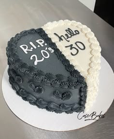 two heart shaped cakes sitting on top of a white cake plate with black and white frosting