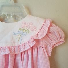 "- This gorgeous vintage dress is ready to be worn again! It is pink gingham with short sleeves and buttons at back of neck. There is a large, round collar trimmed in gingham ruffles. The white on collar is embroidered with pink flowers with greens and a bow. So perfect for Easter. size is: 9 months (2 available) Length: 13.75\" + 3\" hem allowance" Embroidered Baby Clothes, Baby Dress Embroidery, Pink Gingham Dress, Dress Ruffles, Vintage Baby Clothes, Dress Embroidery, Frocks For Girls, Pink Gingham