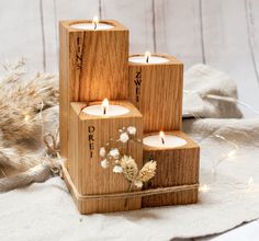 three wooden blocks with lit candles in them