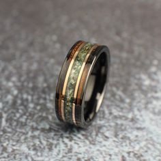 a wedding ring with gold and green wood inlays on the inside of it