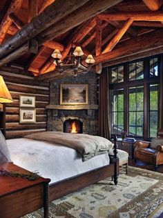 a bedroom with a fireplace in the middle and lots of wood on the walls,