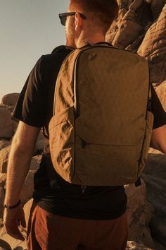 a man with a backpack is standing on some rocks