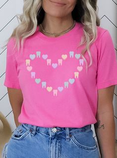 ✦ St. Patrick's Day version of this shirt: https://www.etsy.com/listing/1390930938/ Get ready to be OBSESSED with this cute tooth and candy heart Valentine shirt. Buy today for yourself or for someone special.  Q U I C K F A C T S  ✦ Unisex Bella+Canvas 3001 available in: black, charity pink, maroon, heather raspberry, and red ✦ Light fabric ✦ Retail fit/ runs true to size ✦ Printed and shipped from the USA with love  S I Z I N G  ✦ Runs true to size ✦ Solid colors are 100% cotton except Ash - 9 Pink Crew Neck Shirt For Valentine's Day, Cute Shirt With Heart Graphic And Crew Neck, Cute Crew Neck Shirt With Heart Graphic, Pink Short Sleeve Shirt With Heart Graphic, Valentines Dental, Dental Shirt, Dental Shirts, Cute Tooth, Christmas Apparel