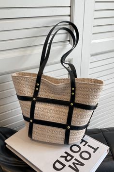 Medium sized straw tote with vegan leather strap and metal stud designs. Long leather top handles. Black Straw Bags With Large Capacity, Black Straw Tote Bag, Black Straw Top Handle Shoulder Bag, Straw Bag With Gold-tone Hardware For Everyday, Black Beach Bag With Braided Handles For Spring, Spring Black Beach Bag With Braided Handles, Summer Rectangular Straw Bag With Gold-tone Hardware, Black Leather Bucket Bag For Vacation, Everyday Black Straw Beach Bag