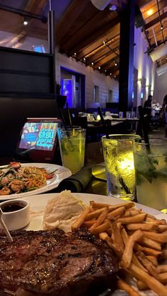 steak, fries and drinks on a table in a restaurant