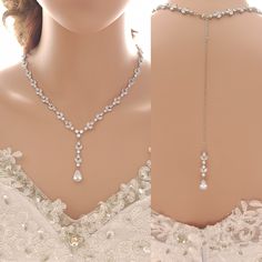 the back of a woman's wedding dress with a necklace and earrings on it