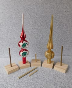 three different types of christmas decorations on wooden bases and stands in front of a gray wall