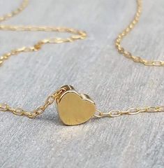 The most dainty gold necklace, such a cute tiny 14K gold-filled heart necklace.  Little goldfilled heart on a dainty 14k goldfilled chain.  Perfect with layering with other necklaces in my shop!  The necklace on the model measures 16 inches.  14k goldfilled little heart pendant measures 6 mm, so simple and sweet! You can wet the necklace and it will not tarnish - Acts like real gold  Photo #5 - Sterling Silver necklace (choose your choice from the drop-down menu)  ♥ It comes in a beautiful package ready for gifting.  View more dainty Necklaces: http://www.etsy.com/shop/HLcollection?section_id=12324188 ENTER OUR SHOP HERE for more stunning jewelry :  https://hlcollection.etsy.com ♥ ----------------------------------------------------------------------- ALL USA ORDERS: Shipping Transit Time Small Pendant Necklace, Dainty Heart Necklace, Tiny Heart Necklace, Heart Charm Necklace, Packing Jewelry, Dainty Gold Necklace, Gift Love, Necklace Heart, Tiny Heart