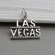 "This Las Vegas Charm comes with a silver jump-ring as pictured. Please note that photo is not to scale and may appear larger to show detail. Refer to exact measurements below. Additional attachments (lobster clasp, large-hole bead, necklace chains) are available from the charm-attachments drop-down menu.  For a visual example of the different attachments and what each one is best suited for, scroll through the photos until you see the example photo or visit https://etsy.me/2BY7DAW for detailed information.    { DETAILS } ★ Material: Sterling Silver ★ Finish Color: Silver  ★ Measurements: 1/2\" x 3/4\" ★ Dimensions: One-sided ★ Made in the USA { SIMILAR ITEMS }  More casino and gambling themed items available from my shop: https://www.etsy.com/shop/treasuredcharms/search?search_query=casin Engraved Silver Charms, Personalized Silver Charm Bracelet With Pendant, Silver Nickel-free Bracelet Souvenir, Nickel-free Silver Bracelets As Souvenir, Silver Symbolic Jewelry Souvenir, Adjustable Engraved Silver Charms, Casino Theme Necklace, Personalized Sterling Silver Charms For Collectors, Nickel-free Silver Charms Souvenir